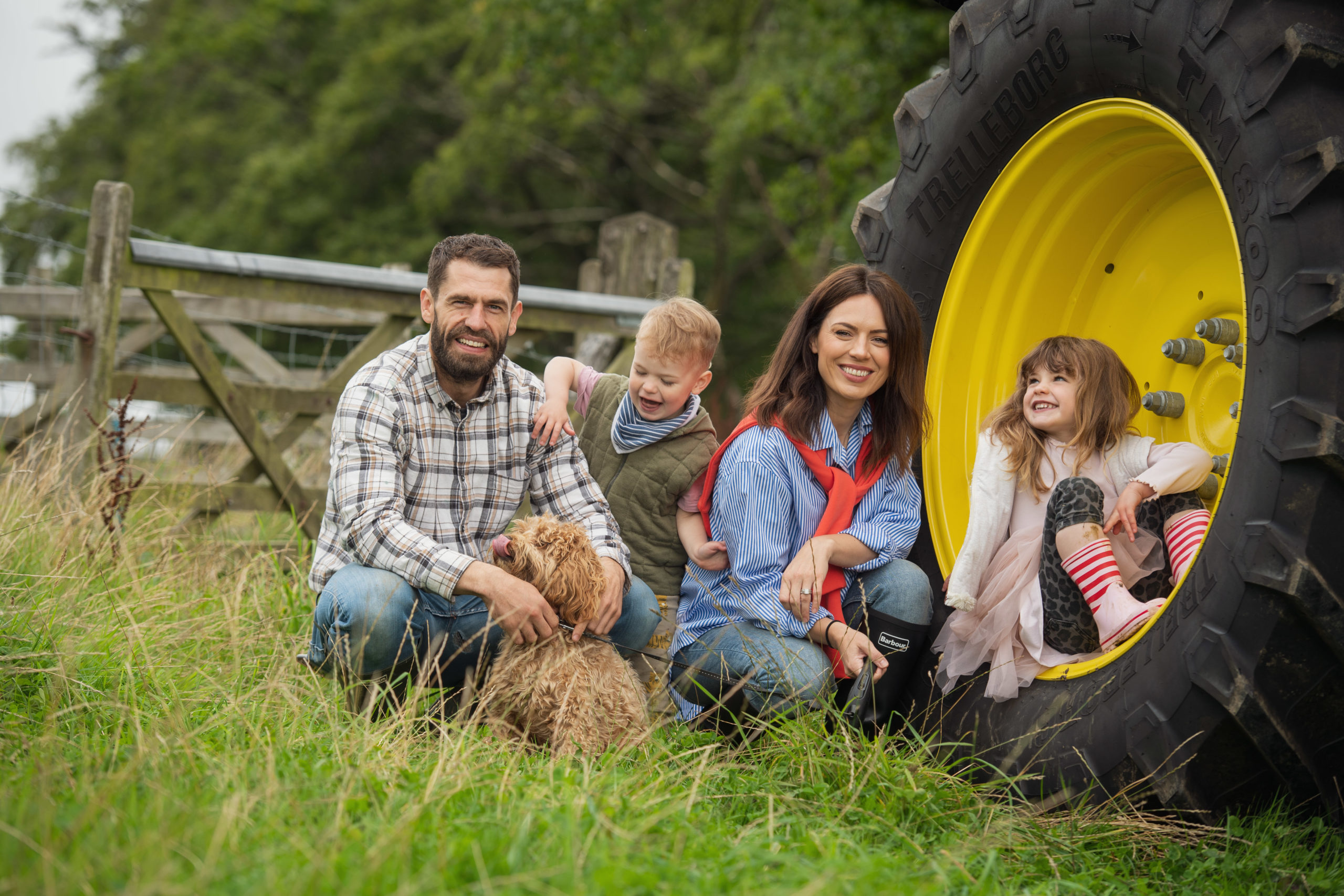 TV star Kelvin Fletcher and family in fiarm field with tractor for publicity photography