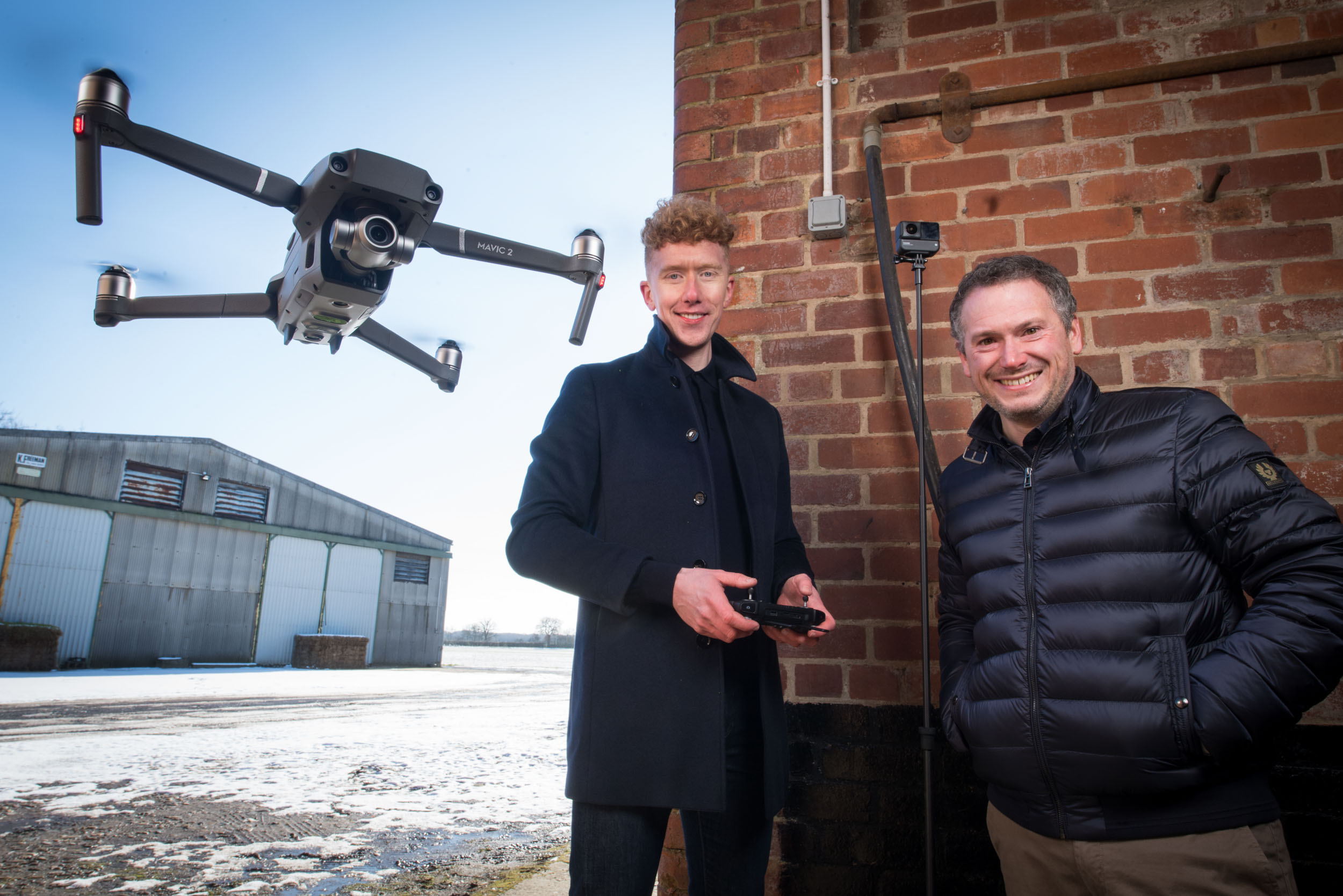 A drone is photographed being flown whilst it films a commercial video.
