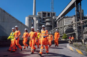 Engineering apprentices walking through industrial site. Industrial photographer at cement works in Peak District